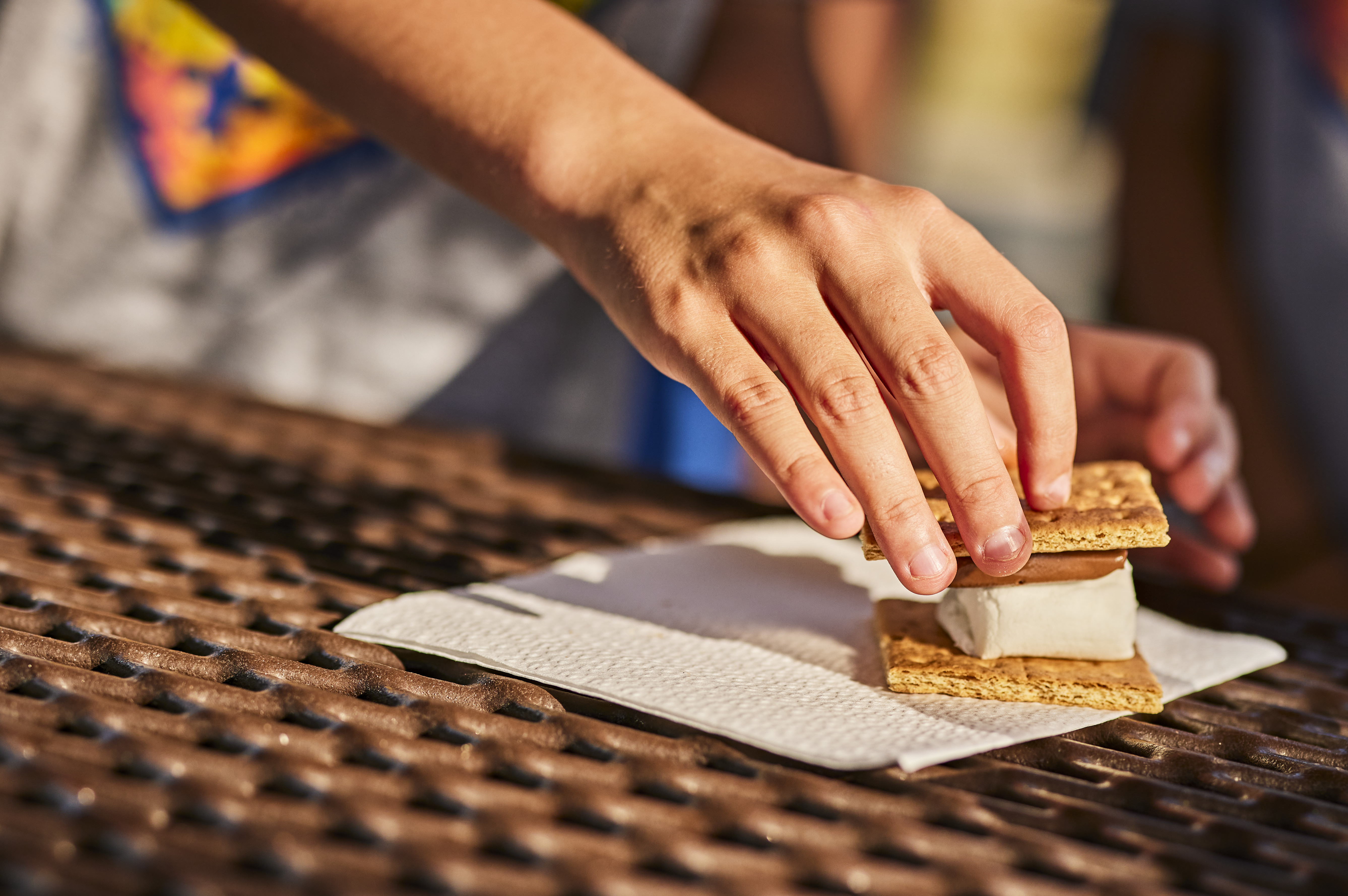 Scouts making s'mores at a campfire